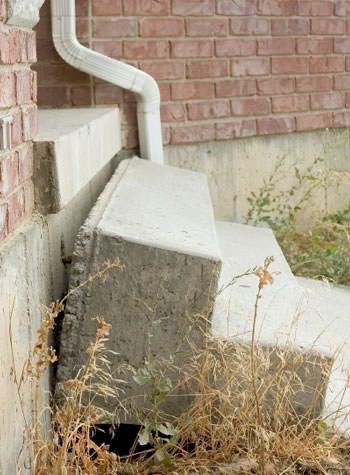 sinking outdoor concrete steps showing cracking and soil washout in Donnellson