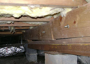 A sagging crawl space with concrete supports and wooden shimming a Hamilton crawl space