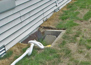 The ugly, old concrete window well of a Kirksville crawl space