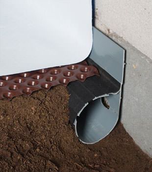 Closeup of a crawl space drainage system installed in Edina