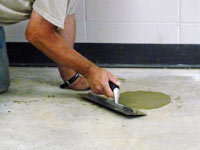 Repairing the cored holes in the concrete slab floor with fresh concrete and cleaning up the Rushville home.