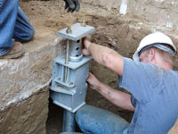 Foundation repair contractors installing the foundation bracket in Kirksville.