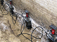 Using foundation push piers to lift a foundation during a repair in West Burlington.
