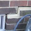A closeup of a failed tuckpointing job where the brick cracked on a Bellflower home.