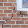 long jagged cracks starting at the corner of a window along a brick wall on a Colchester home