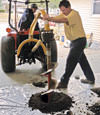 Digging a hole in the garage floor to make room for a wall anchor installation in Liberty, Illinois, Iowa, and Missouri