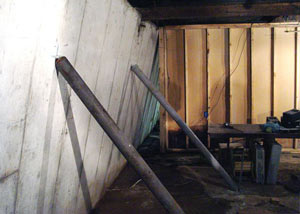 A severely tilting foundation wall propped up by steel beams in Bellflower.