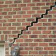 stair step cracking reaching from a window along the foundation wall in Kirksville