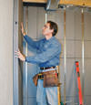 Insulated basement wall panels being placed against a concrete foundation wall in Mount Sterling